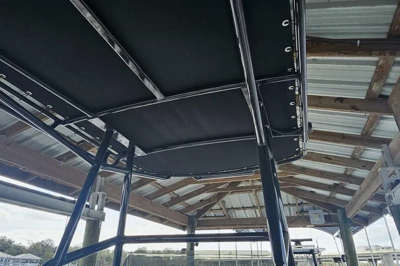 Slide: The Image of 2021 Flats Cat 21' boat under a wooden dock roof, showcasing its sturdy frame. - 15