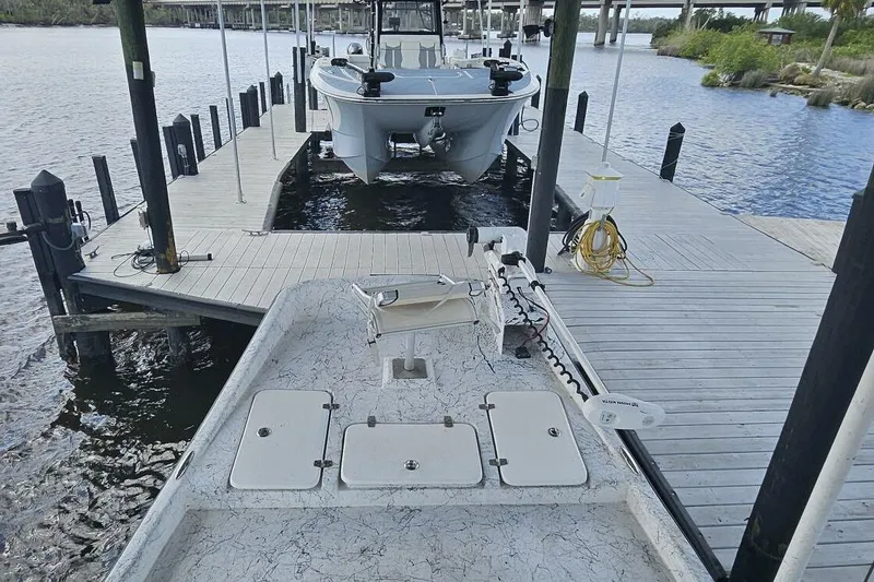 Slide: The Image of 2021 Flats Cat 21' boat docked at a marina with wooden walkways. - 21