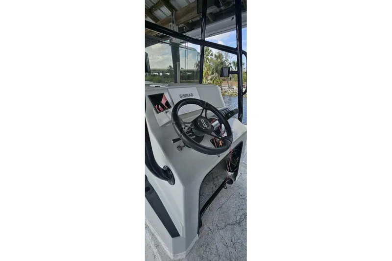 Slide: The Image of 2021 Flats Cat 21' boat console with steering wheel and Simrad display. - 24