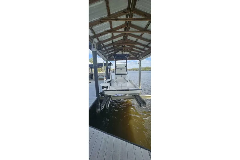 Slide: The Image of 2021 Flats Cat 21' boat docked under a covered structure on the water. - 3