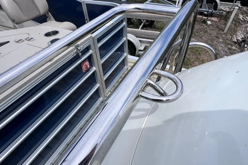 Slide: The Image of 2018 Berkshire 25 STS Tri Toon boat with shiny metal railings and seating. - 12