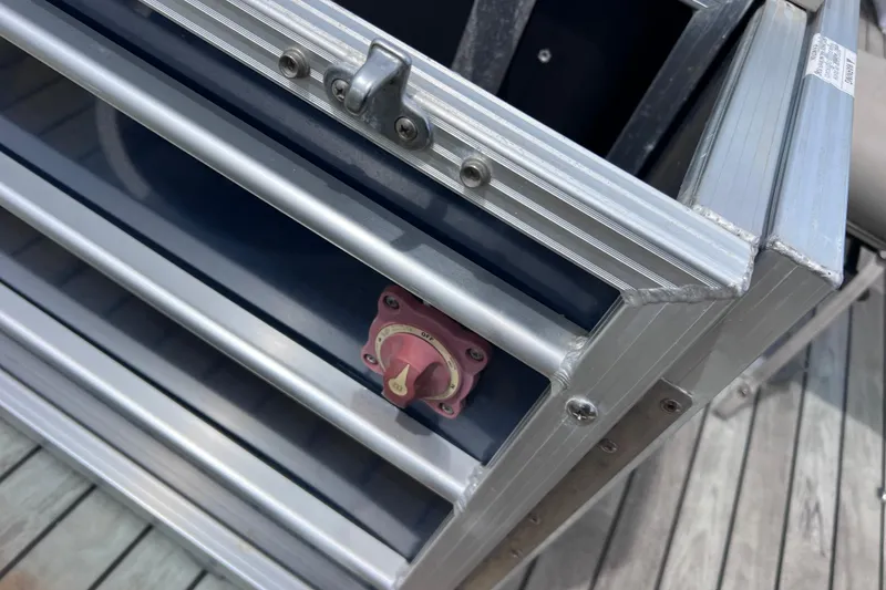 Slide: The Image of Close-up of a 2018 Berkshire 25 STS Tri Toon boat's metal compartment with a red switch. - 13