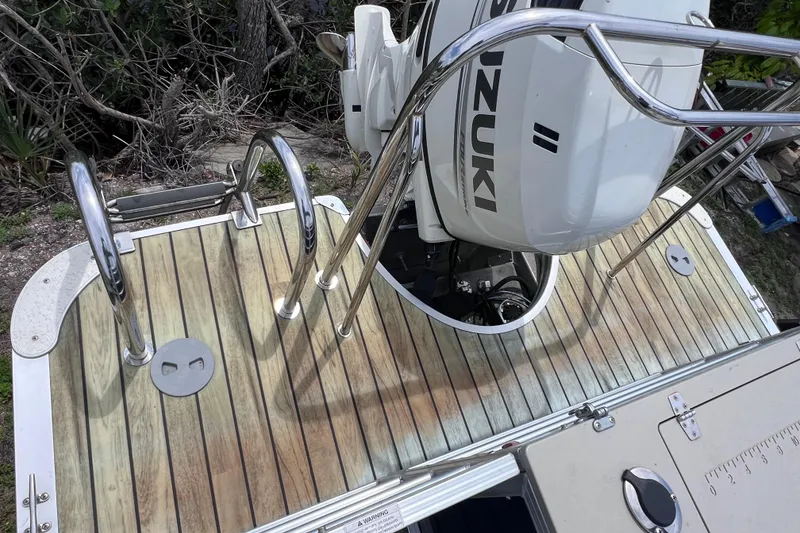 Slide: The Image of 2018 Berkshire 25 STS Tri Toon boat with Suzuki outboard motor and wooden deck. - 14