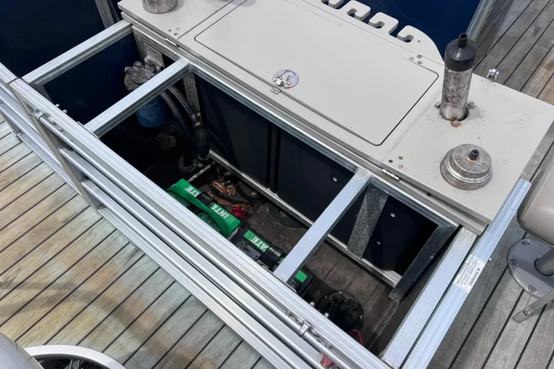 Slide: The Image of 2018 Berkshire 25 STS Tri Toon boat interior with visible battery compartment and deck. - 17