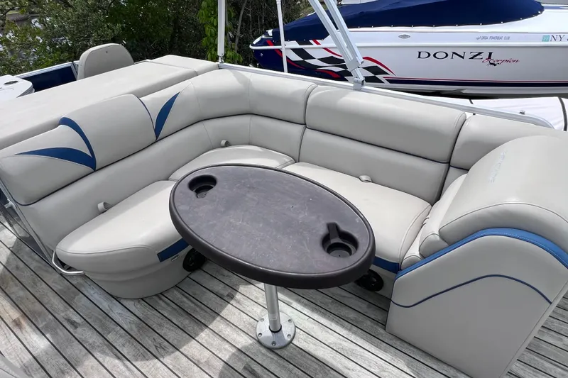Slide: The Image of 2018 Berkshire 25 STS Tri Toon boat with cushioned seating and table on deck. - 18