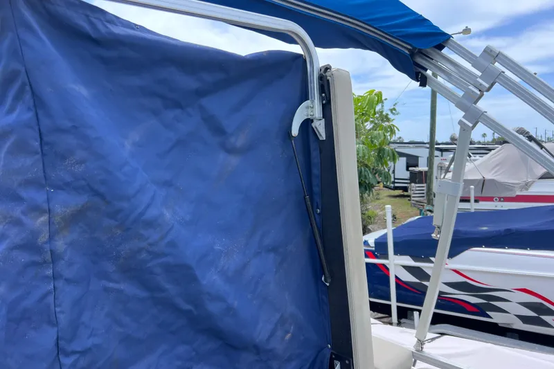 Slide: The Image of Blue canopy on a 2018 Berkshire 25 STS Tri Toon boat, docked outdoors. - 19
