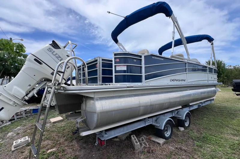 Slide: The Image of 2018 Berkshire 25 STS Tri Toon pontoon boat with Suzuki outboard motor on trailer. - 2