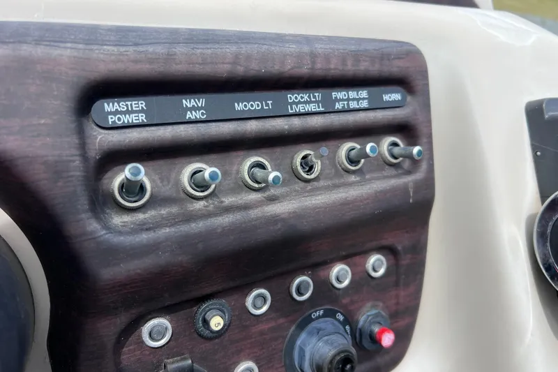 Slide: The Image of Control panel of a 2018 Berkshire 25 STS Tri Toon boat with labeled switches. - 24