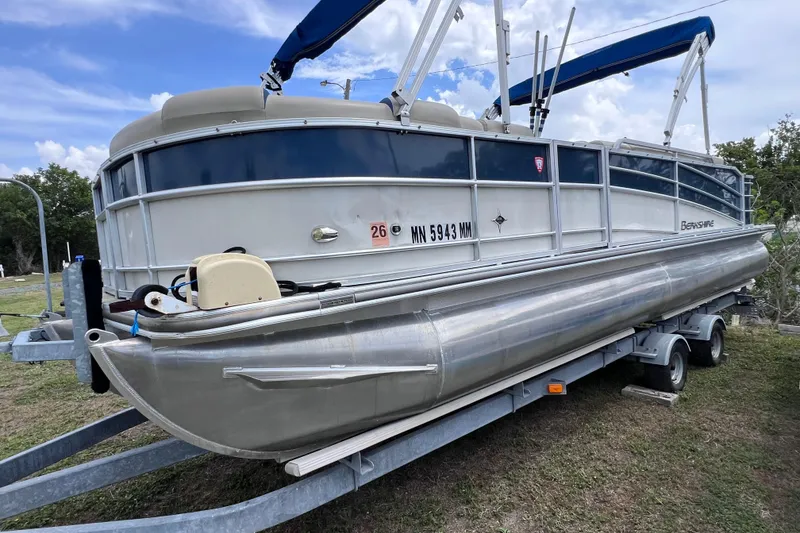 Slide: The Image of 2018 Berkshire 25 STS Tri Toon pontoon boat on trailer, blue canopy, parked on grass. - 3