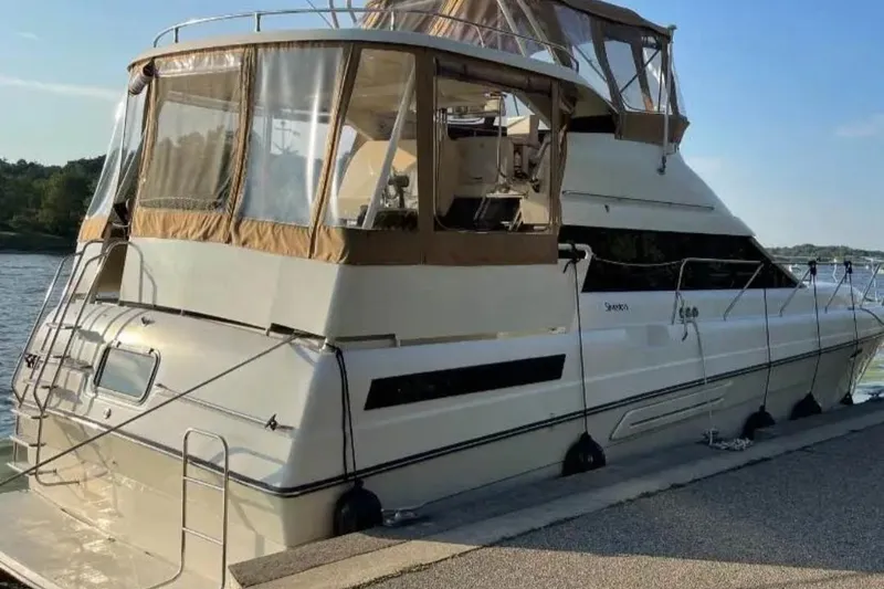 Slide: The Image of 1991 Silverton 41 Motor Yacht docked by the water on a sunny day. - 54