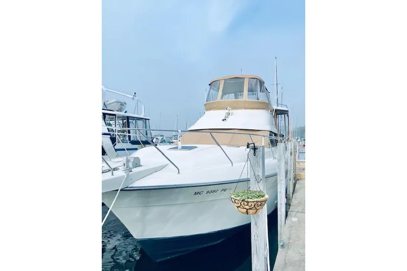 Slide: The Image of 1991 Silverton 41 Motor Yacht docked at marina, clear sky background. - 55