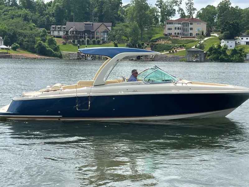 The Image of 2020 Chris-Craft Launch 31 GT boat on a serene lake with luxury homes in the background. - 0