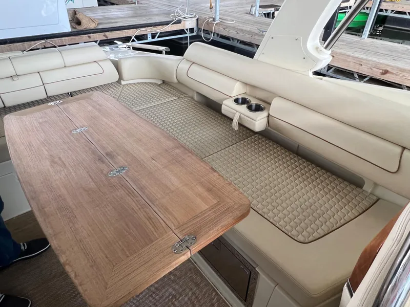 Slide: The Image of 2020 Chris-Craft Launch 31 GT boat interior with beige seating and wooden table. - 15