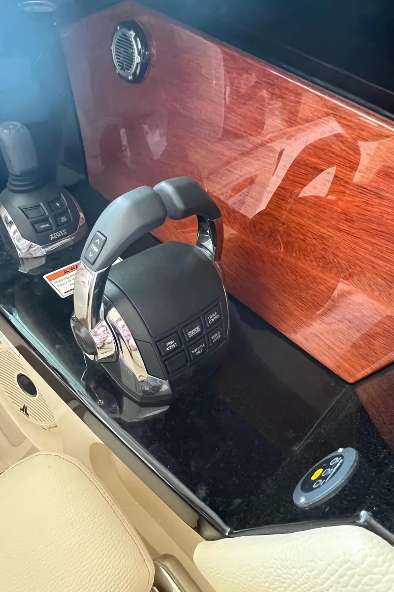 Slide: The Image of 2020 Chris-Craft Launch 31 GT boat controls with wood paneling and modern throttle system. - 24