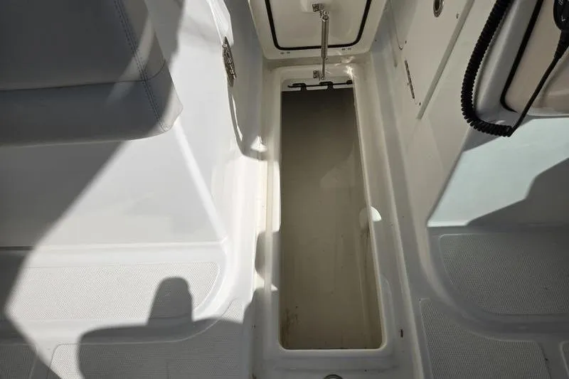 Slide: The Image of 2020 Boston Whaler 270 Vantage storage compartment, open and empty, with white interior. - 20