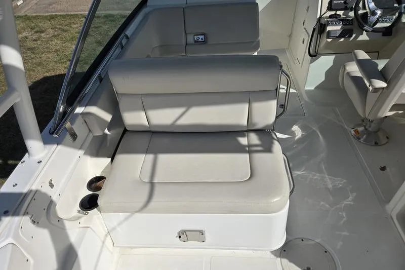 Slide: The Image of 2020 Boston Whaler 270 Vantage boat interior with beige seating and steering console. - 4