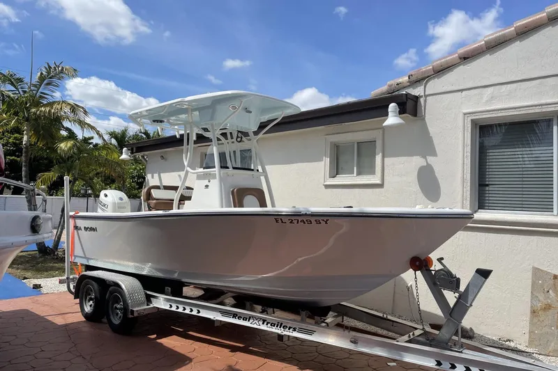 Slide: The Image of 2020 Sea Pro 219 Center Console boat on trailer, parked beside a house. - 12