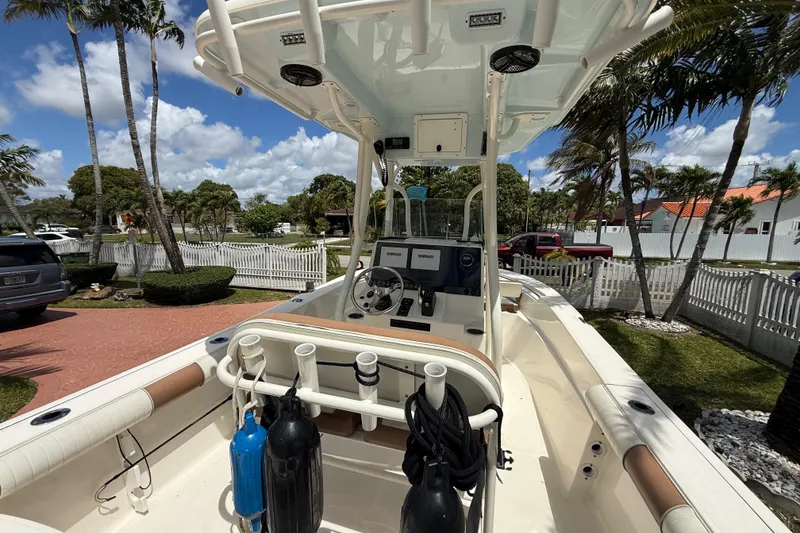 Slide: The Image of 2020 Sea Pro 210 Center Console boat with modern dashboard, parked in a sunny residential area. - 18