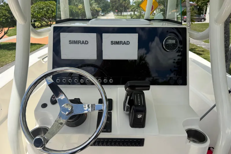 Slide: The Image of 2020 Sea Pro 210 Center Console dashboard with Simrad displays and steering wheel. - 19