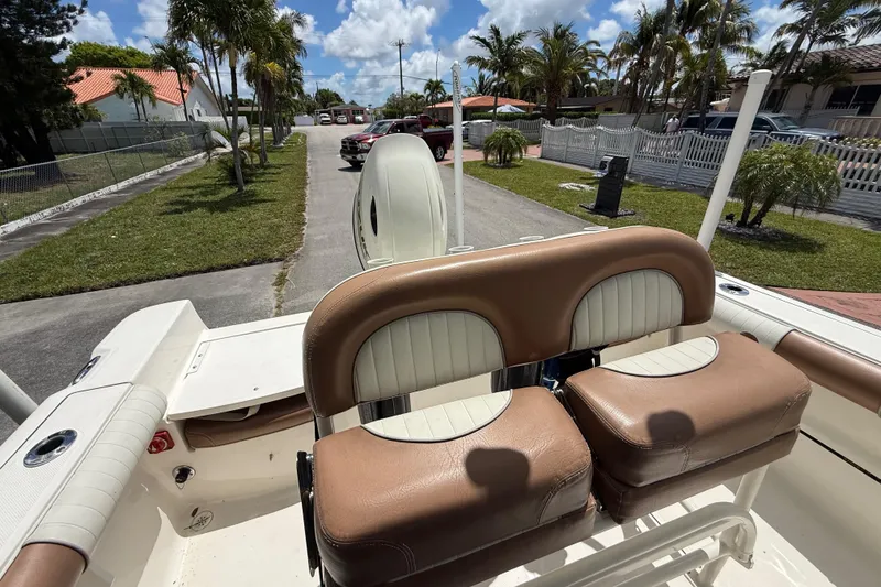 Slide: The Image of 2020 Sea Pro 210 Center Console boat with brown and white seating, parked in a residential area. - 21