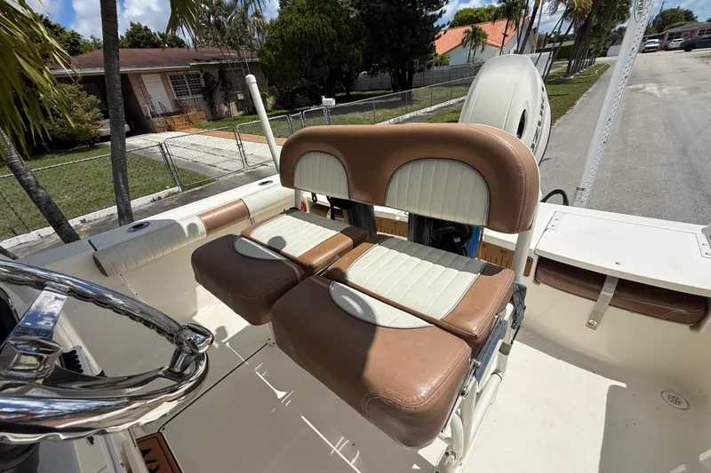 Slide: The Image of 2020 Sea Pro 210 Center Console boat with brown and white seating, parked in a residential area. - 22