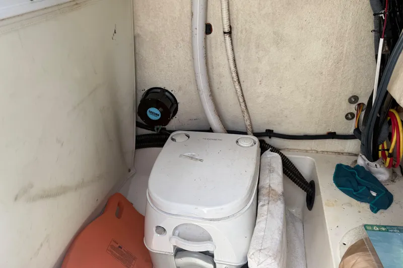 Slide: The Image of 2020 Sea Pro 210 Center Console boat interior with portable toilet and storage area. - 30