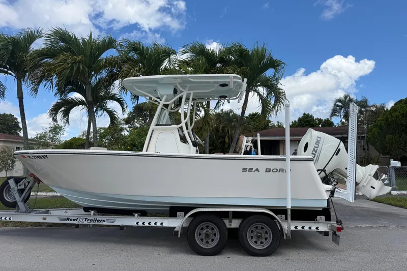Slide: The Image of 2020 Sea Pro 210 Center Console boat on trailer, parked near palm trees. - 34