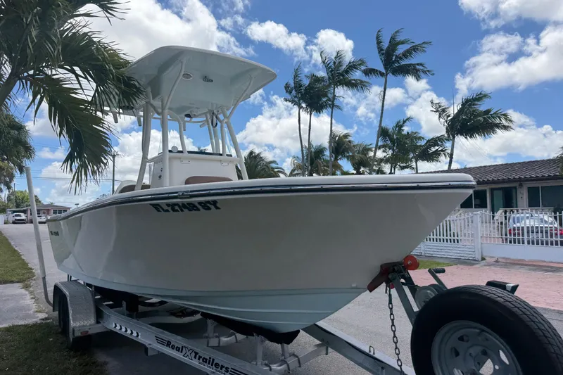 Slide: The Image of 2020 Sea Pro 210 Center Console boat on trailer, surrounded by palm trees and blue sky. - 35