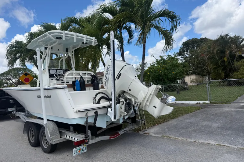Slide: The Image of 2020 Sea Pro 210 Center Console boat on trailer, parked near palm trees. - 37