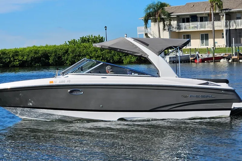 The Image of 2010 Regal 2700 ES Bowrider cruising on a sunny day near waterfront homes. - 0