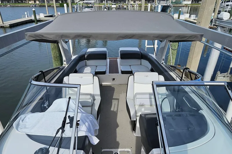 Slide: The Image of 2010 Regal 2700 ES Bowrider with canopy, docked at marina, featuring spacious seating. - 22