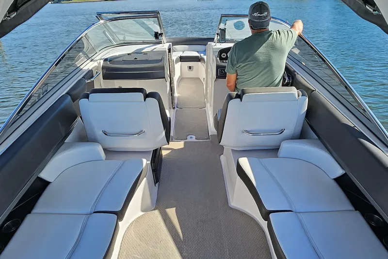 Slide: The Image of 2010 Regal 2700 ES Bowrider interior with seating and driver on a calm lake. - 32