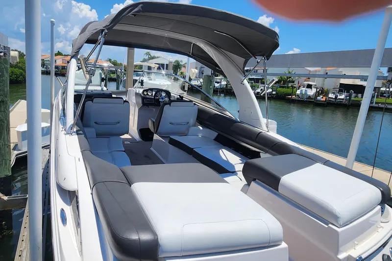 Slide: The Image of 2010 Regal 2700 ES Bowrider boat with spacious seating, docked by a scenic waterfront. - 4