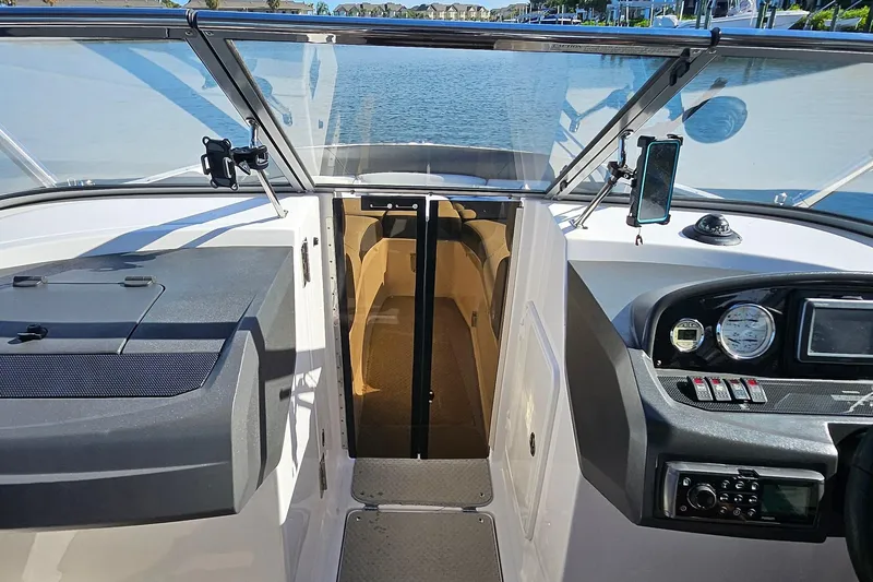 Slide: The Image of 2010 Regal 2700 ES Bowrider cockpit with dashboard and open cabin door. - 45