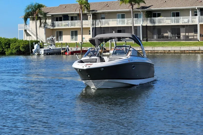 Slide: The Image of 2010 Regal 2700 ES Bowrider on calm water near waterfront homes. - 52