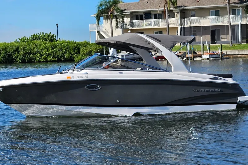 Slide: The Image of 2010 Regal 2700 ES Bowrider cruising on a sunny day near waterfront homes. - 56