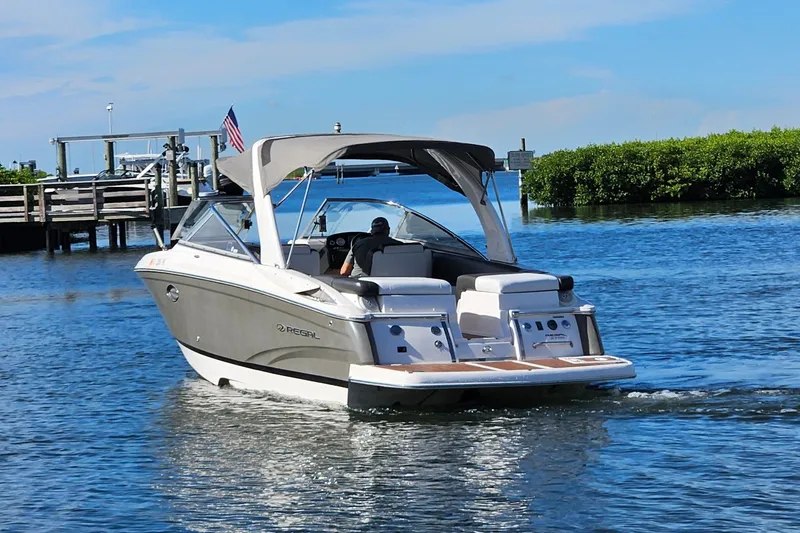 Slide: The Image of 2010 Regal 2700 ES Bowrider cruising on a sunny day near a dock. - 60