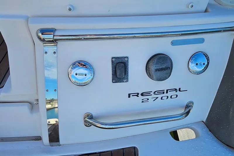 Slide: The Image of 2010 Regal 2700 ES Bowrider boat stern with chrome details and branding. - 62