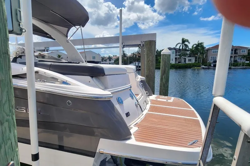 Slide: The Image of 2010 Regal 2700 ES Bowrider docked by waterfront homes under a cloudy sky. - 8