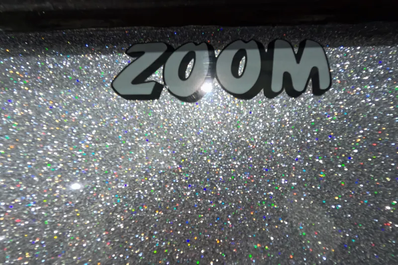 Slide: The Image of "Zoom" text on sparkling silver glitter background, Skeeter 2025. - 13