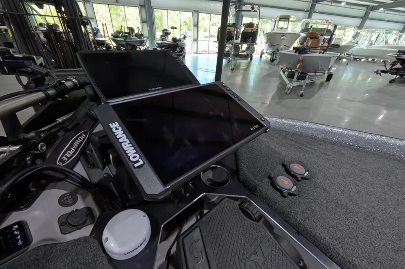 Slide: The Image of 2025 Skeeter boat dashboard with Lowrance and Garmin displays in a showroom. - 6