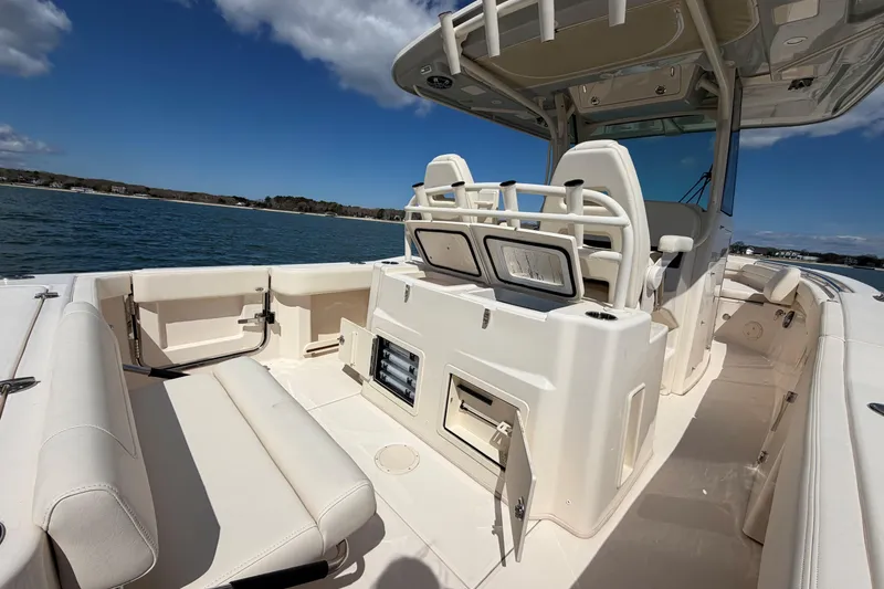 Slide: The Image of 2025 Grady-White Canyon 306 boat interior, featuring seating and storage, on a sunny day at sea. - 12