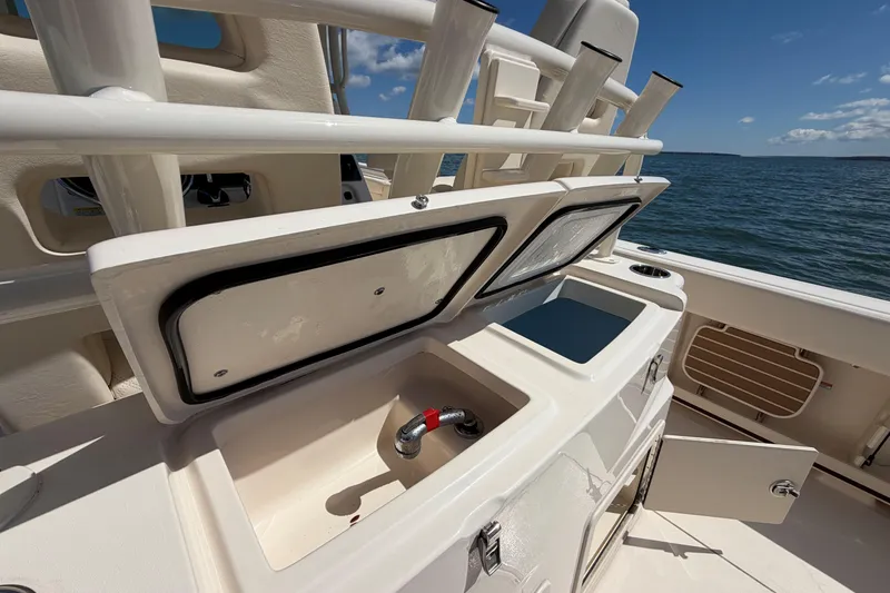 Slide: The Image of 2025 Grady-White Canyon 306 boat interior with open storage compartments and ocean view. - 13