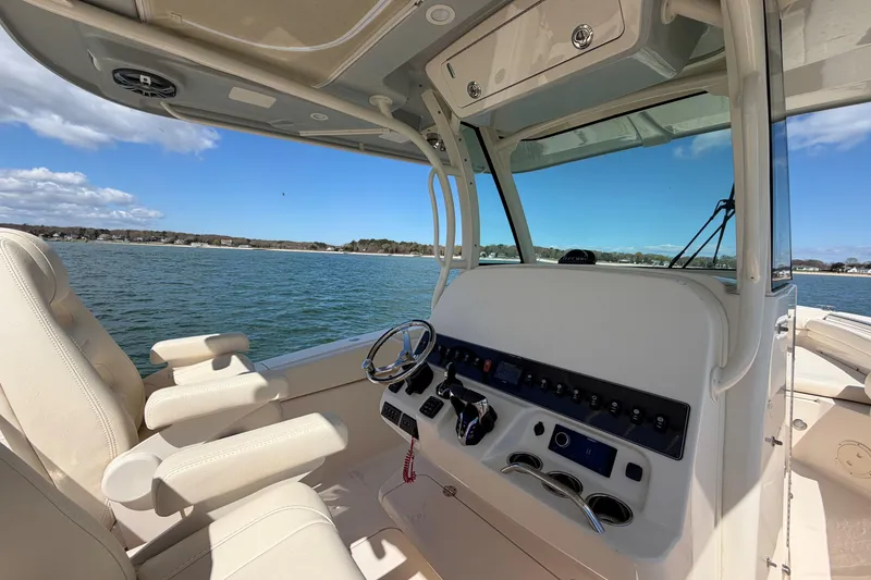 Slide: The Image of 2025 Grady-White Canyon 306 boat interior with steering wheel and control panel. - 19
