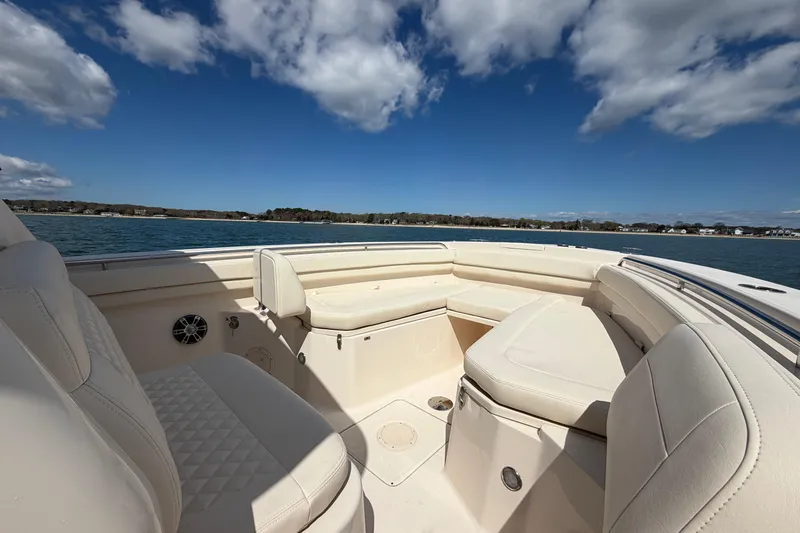 Slide: The Image of 2025 Grady-White Canyon 306 boat interior with plush seating, on a sunny day. - 24