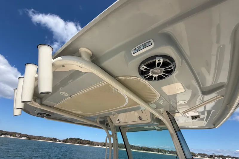 Slide: The Image of 2025 Grady-White Canyon 306 boat roof with rod holders and speaker, under clear sky. - 29