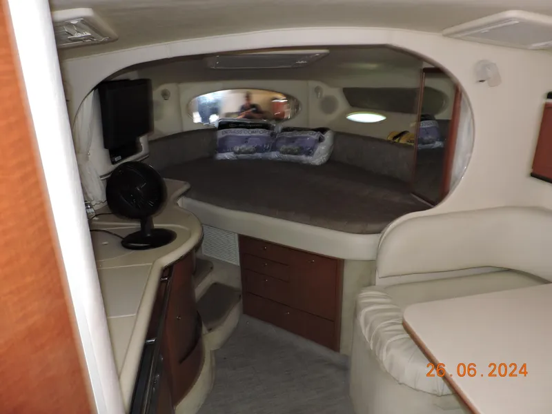 Slide: The Image of 2002 Sea Ray 310 Sundancer cabin interior with bed, seating, and TV. - 11
