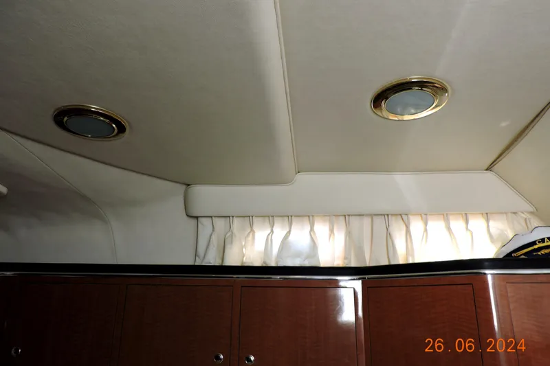 Slide: The Image of Interior cabin of 2002 Sea Ray 310 Sundancer with wood cabinets and ceiling lights. - 14