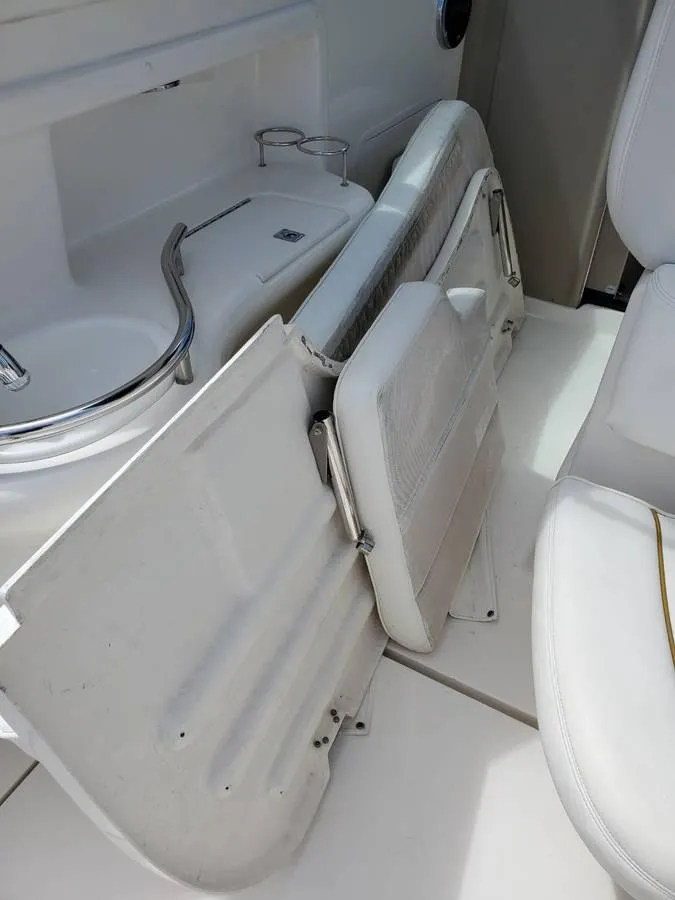 Slide: The Image of 2002 Sea Ray 310 Sundancer interior with white seating and storage compartments. - 16