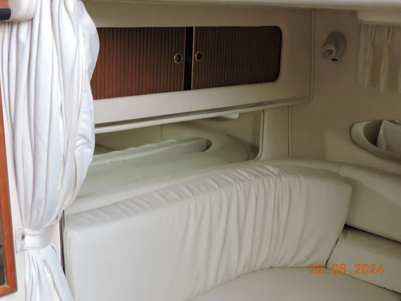 Slide: The Image of Interior cabin of 2002 Sea Ray 310 Sundancer with white upholstery and wooden cabinets. - 19